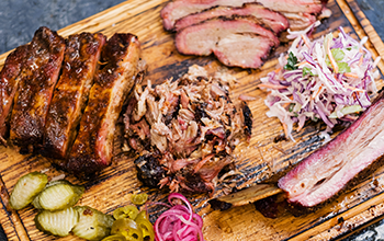 Smoked meat assortment on wooden board