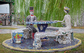 Art skeleton skull mosaic sculpture and a picnic table.