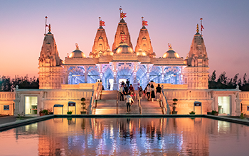 Purple sunset reflection at an orange Hindu temple in Houston Texas